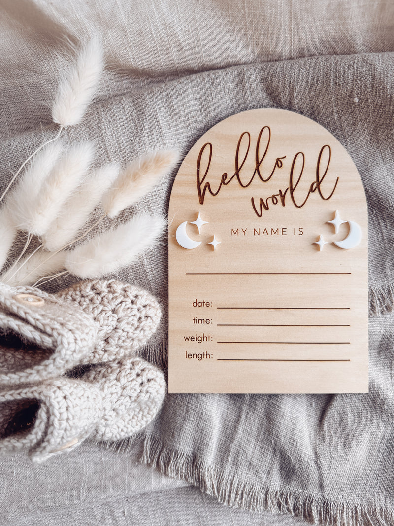 “Hello world" arch announcement plaque with white moons and stars